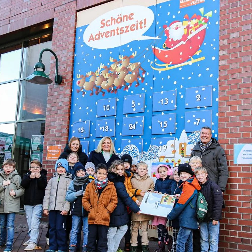Gruppe mit Kindern vor Adventskalender der Stadt Georgsmarienhütte