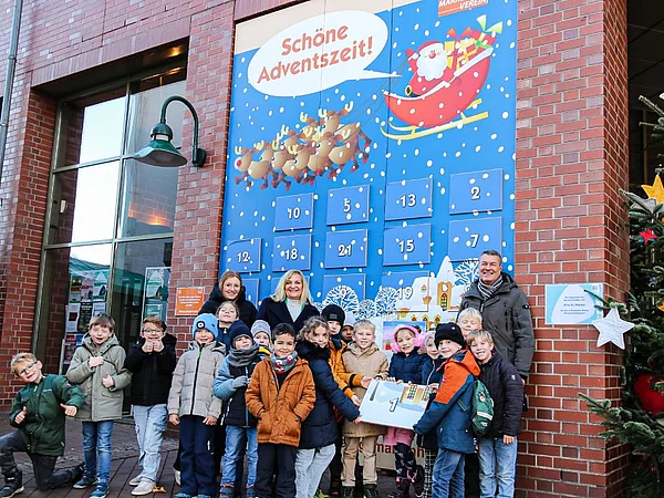 Gruppe mit Kindern vor Adventskalender der Stadt Georgsmarienhütte
